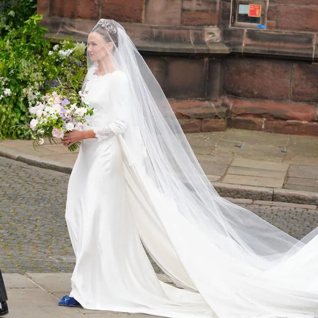 Olivia Henson completó el look de novia con unso zapatos de color azul.