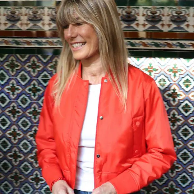 Begoña Gómez con una chaqueta bomber roja y vaqueros. 