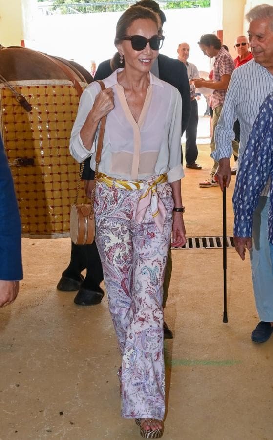 Isabel Preysler con uno de sus looks preferidos formado por pantalón estampado y blusa. 