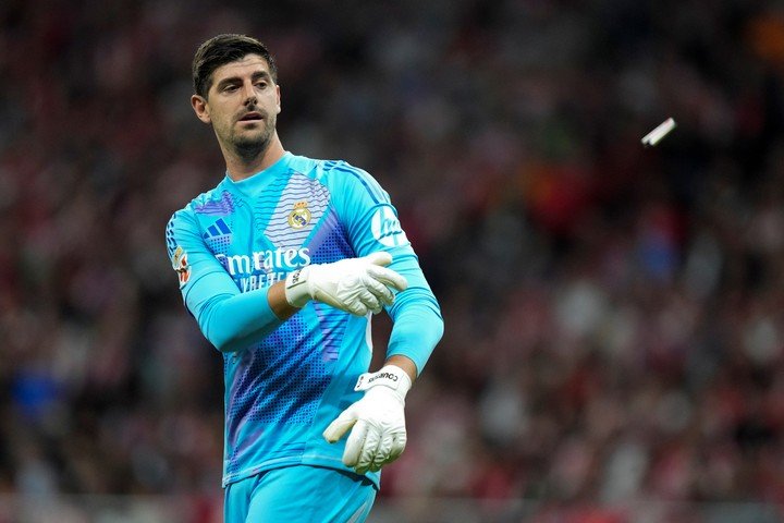 Thibaut Courtois y uno de los objetos arrojados en el Derbi.
(AP Photo/Bernat Armangue)