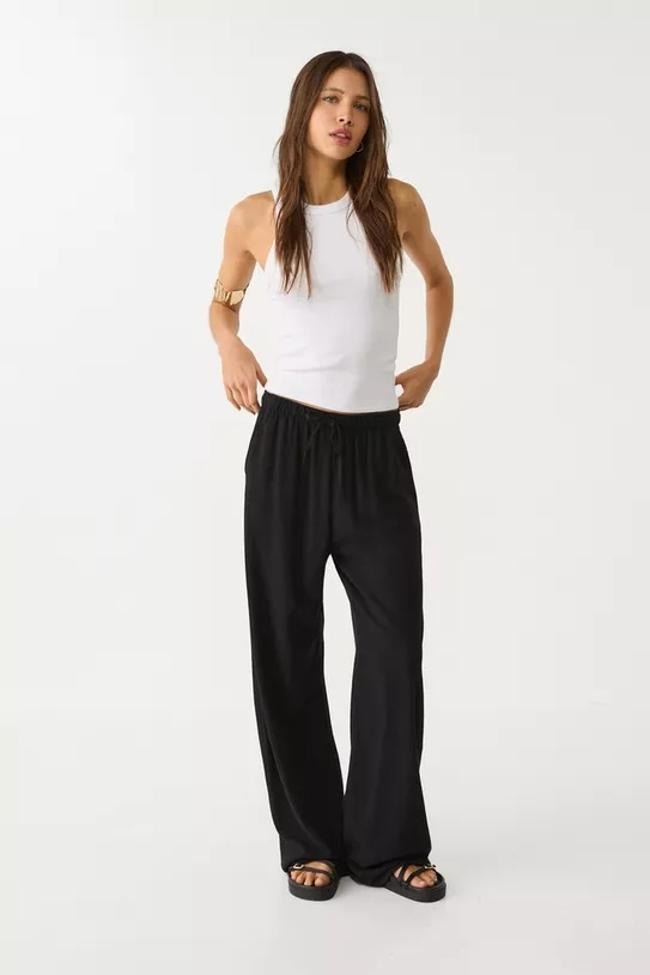Pantalón fluido en negro de Stradivarius.