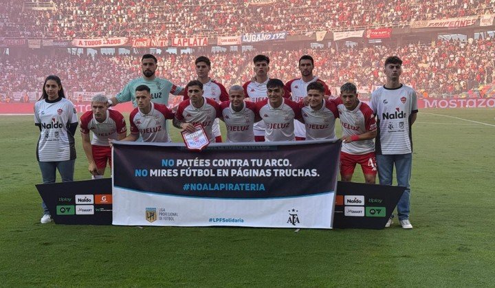 El equipo de Huracán con la publicidad en contra de las páginas truchas.
