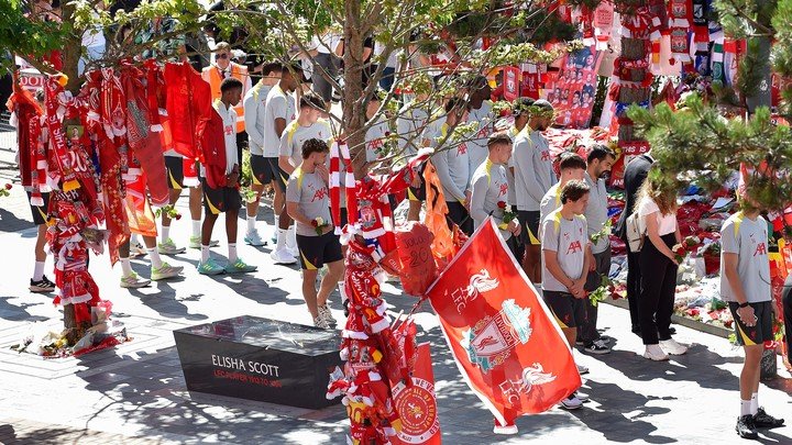 Los jugadores del Liverpool llevan flores.