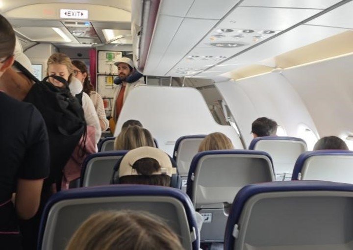 Colapinto, sentado en el avión, con gorra.