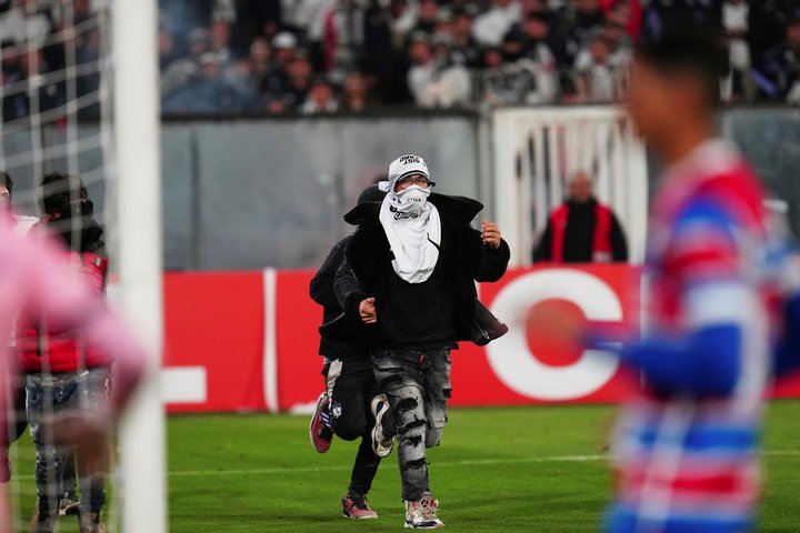 Uno de los ultras de Colo Colo invadiendo la cancha. (AP Photo/Esteban Felix)