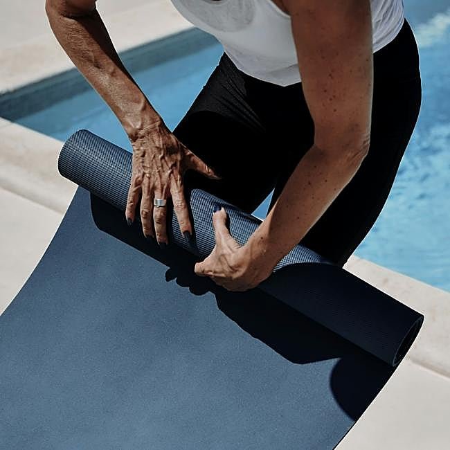 Mujer a punto de empezar a practicar yoga.