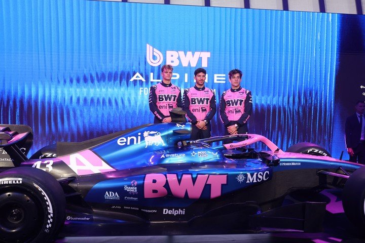 Desde la izquierda, el reserva Paul Aron y los titulares Pierre Gasly y Franco Colapinto, posan con el A526 en su presentación. (Josep LAGO / AFP)