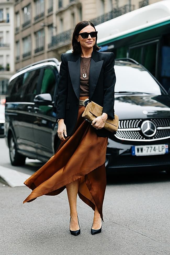 Un look con falda satinada y blazer negro.