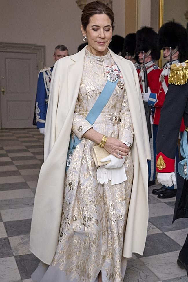 Mary de Dinamarca con un vestido blanco y brocado dorado.