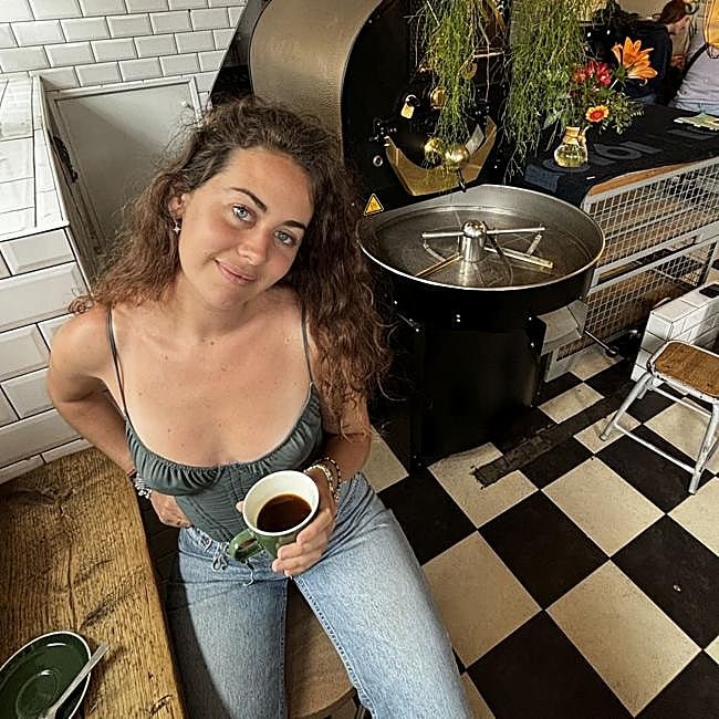 La barista Eira Scheper ante una tostadora de café.