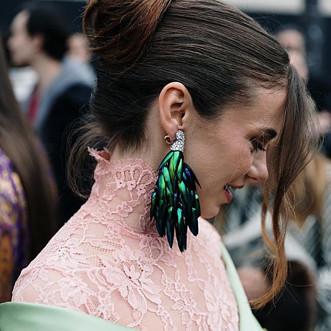 Mujer con pendientes maximalistas