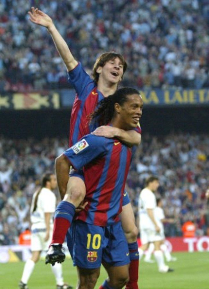 Messi en andas de Ronaldinho tras su primer gol con el Barcelona.