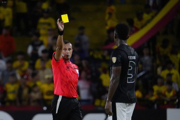 Darío Herrera le muestra la tarjeta amarilla a Félix Torres, defensor del Corinthians.