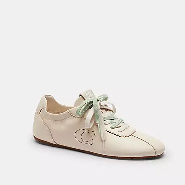 Zapatillas beige con detalles verdes de Coach, 150 euros.