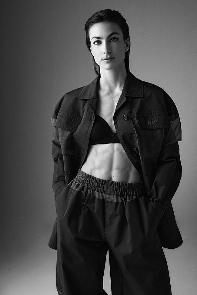 La velocista posa con dos piezas de chaquetón y pantalones con franjas de organza transparente, de Fendi. El top es de la propia atleta