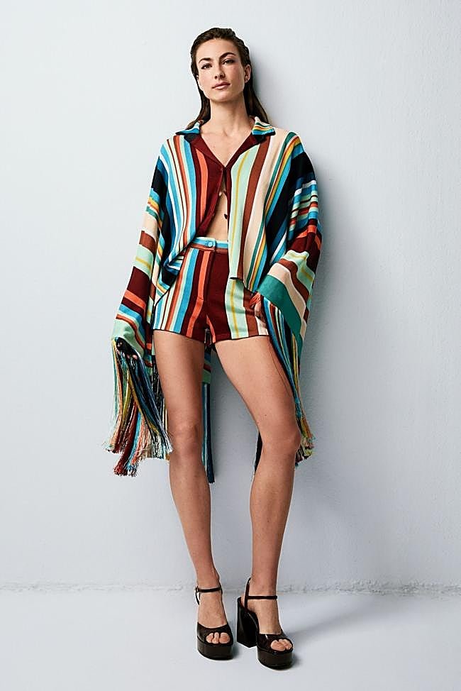 Hervás lleva un conjunto de camisa estilo poncho y shorts de punto. Las sandalias son de piel con plataforma. Todo es de Fendi.