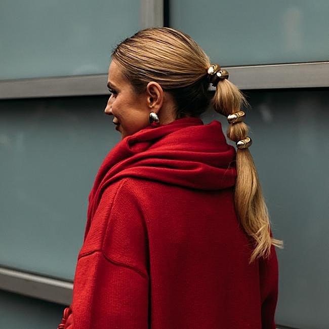 Un look rojo con joyas doradas.