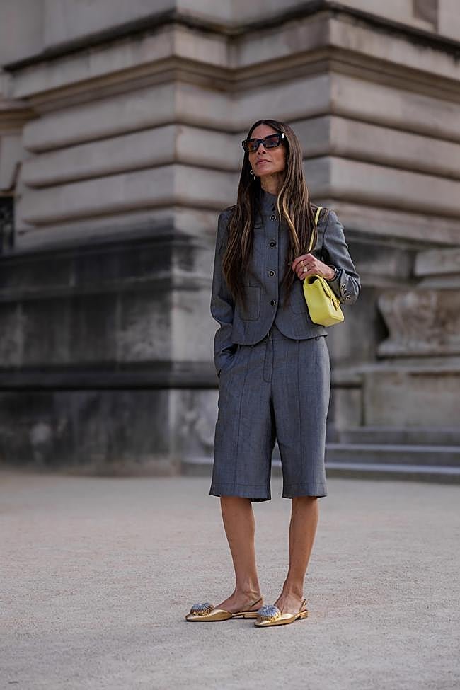 Un look con conjunto en gris, zapatos en dorado y bolso en verde lima.