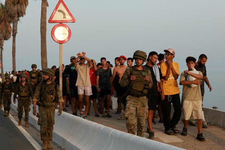 Migrantes escoltados por las fuerzas armadas de España. (REUTER)