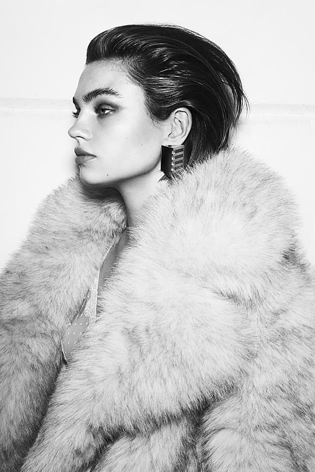 La modelo lleva abrigo de pelo, de Make; sujetador triangular con encaje, de Eres; y pendientes geométricos, de Roberto Cavalli.