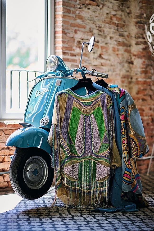 Vestidos de la firma prêt-à-porter Teté by Odette expuestos junto a una moto Vespa restaurada que la diseñadora regaló a su marido y que, aunque hoy preside el atelier, sigue funcionando perfectamente.